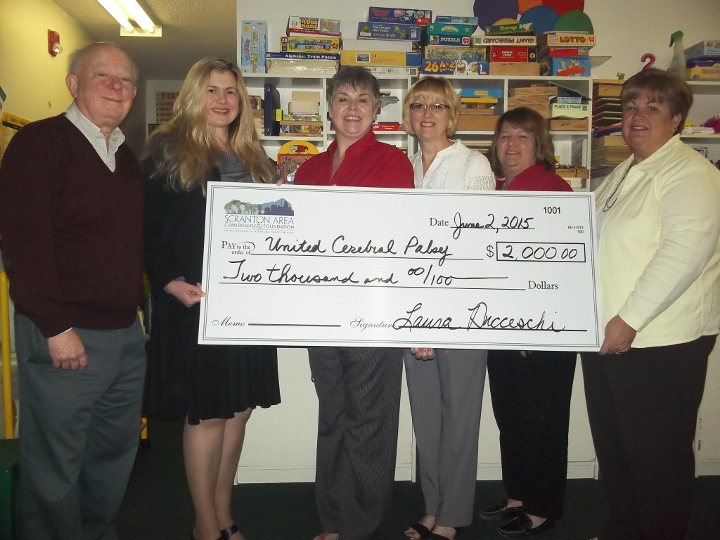 group of people holding a giant check